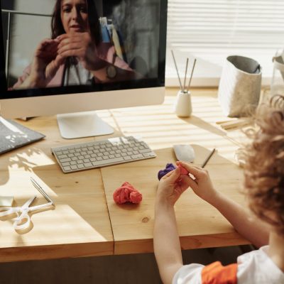 Photo Of Kid Playing With Clay While Looking In The Monitor